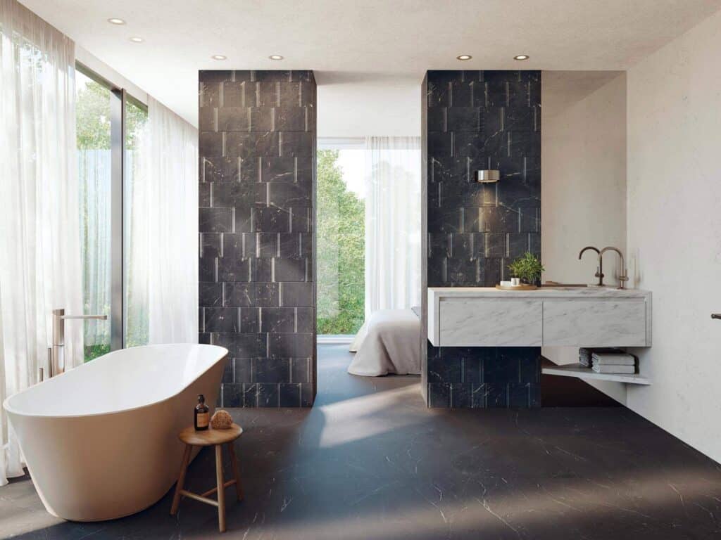 Black and white bathroom with dark marble-effect tiled feature wall, freestanding bath and floating marble vanity