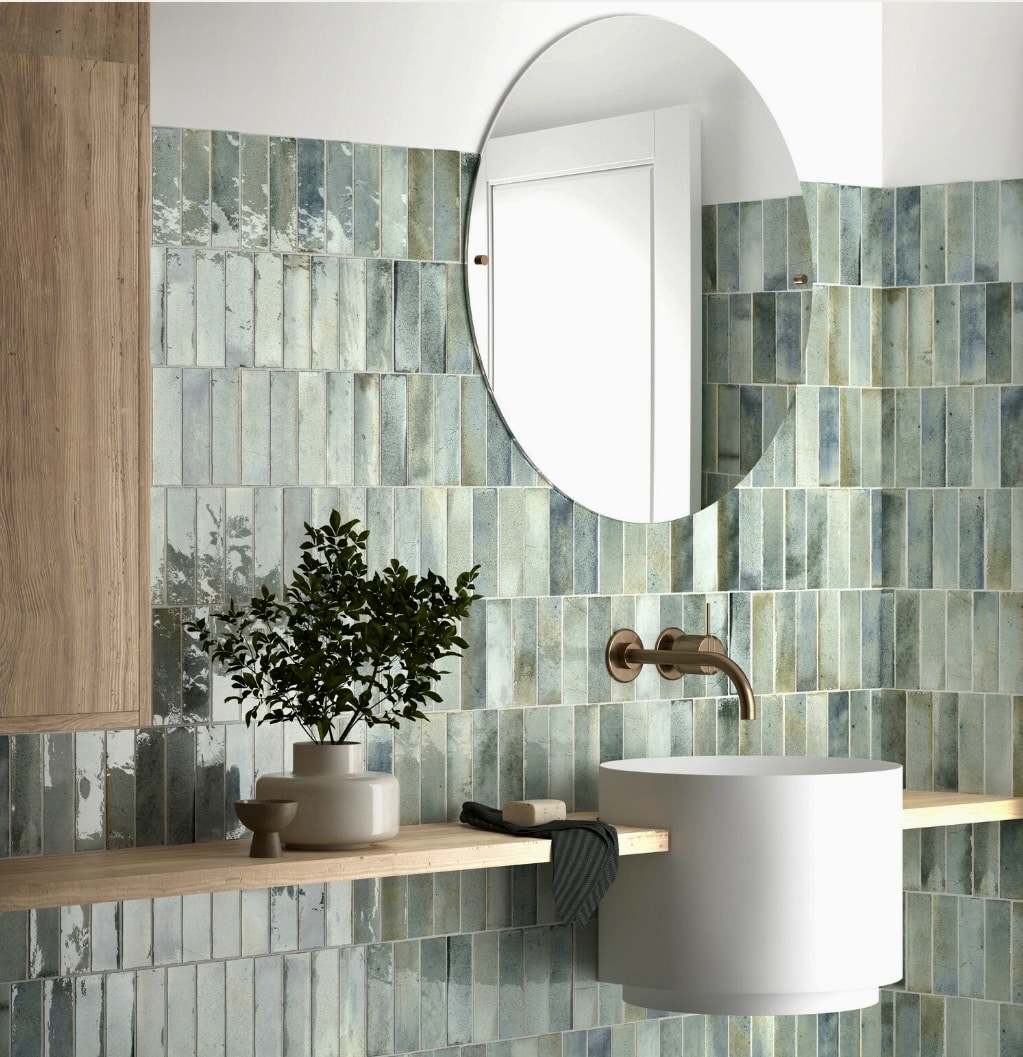 Green bathroom ideas paired with neutral tiles and warm brass details