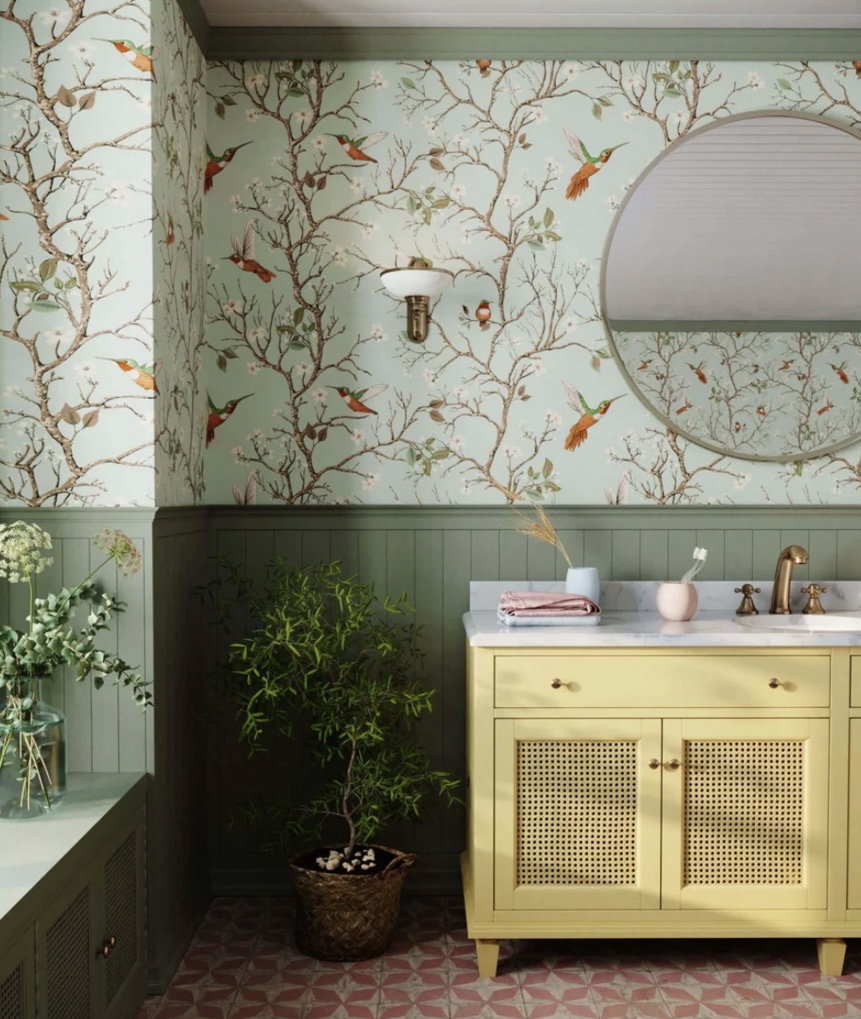 Green bathroom ideas with Bobbi Beck Birds and Branches wallpaper, sage panelling, and yellow vanity for a nature-inspired look