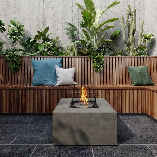 EcoSmart Chaser 38 Fire Pit Table in Natural concrete finish with bioethanol flame, styled in a modern courtyard garden with timber built-in seating​​​​​​​​​​​​​​​​