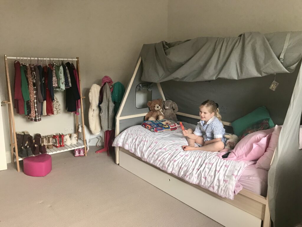 Girls house bed with grey canvas canopy and open clothes rail — girls bedroom ideas