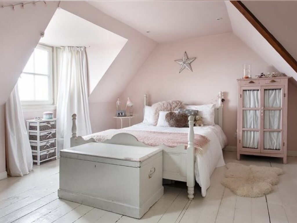Girls attic bedroom with Farrow and Ball Calamine colour drenched walls, white painted floorboards, vintage bed and pink armoire