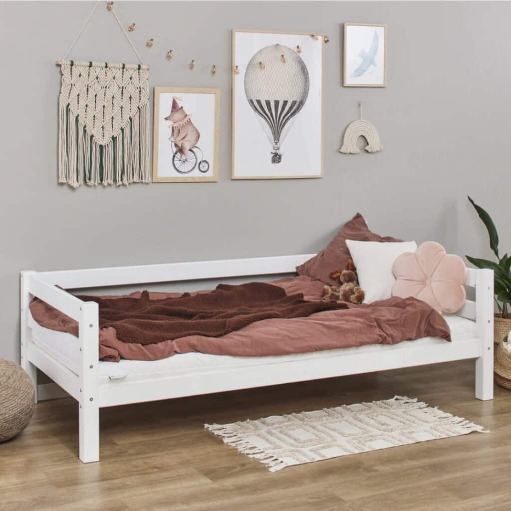 Hoppekids Eco Luxury Junior Bed in white with terracotta bedding, wall art and macramé wall hanging in a girls bedroom