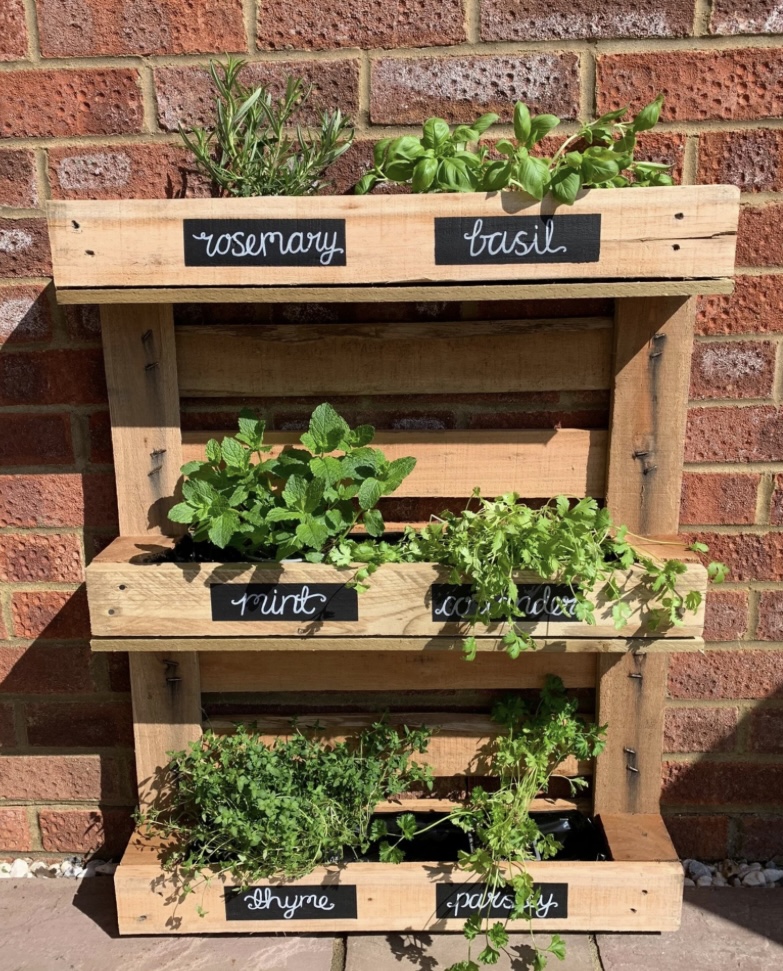 Vertical herb planter in a small courtyard garden, featuring rosemary, basil, mint, and thyme. A space-saving solution for courtyard garden ideas, perfect for adding greenery to compact outdoor spaces.