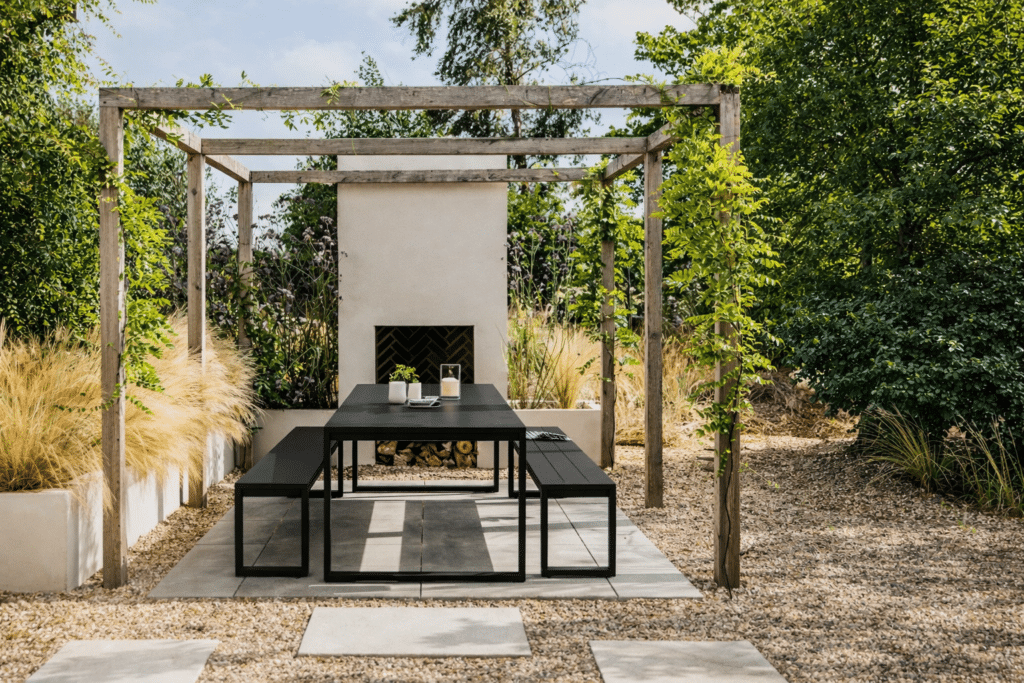 Case Furniture Eos black metal outdoor dining table with benches in a pergola setting
