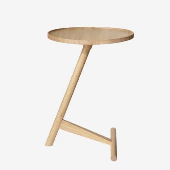 Unique wood side table in oak with angled leg and round top, minimalist design for modern living rooms.