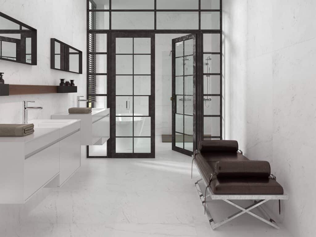 White marble bathroom with Crittall-style black shower doors, white floating vanity and chrome tapsj