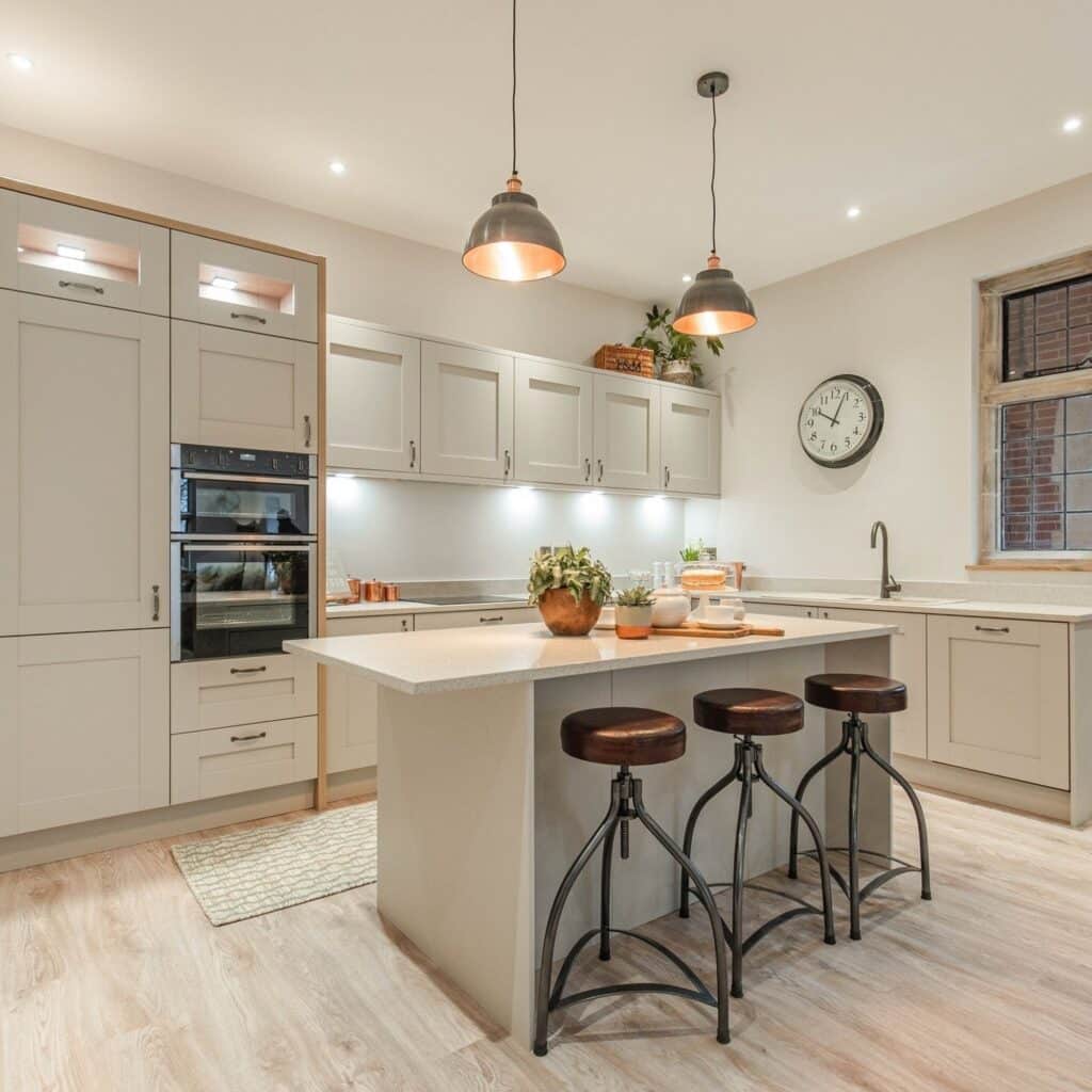 Cream kitchen island with pewter copper pendant lights industrial stools