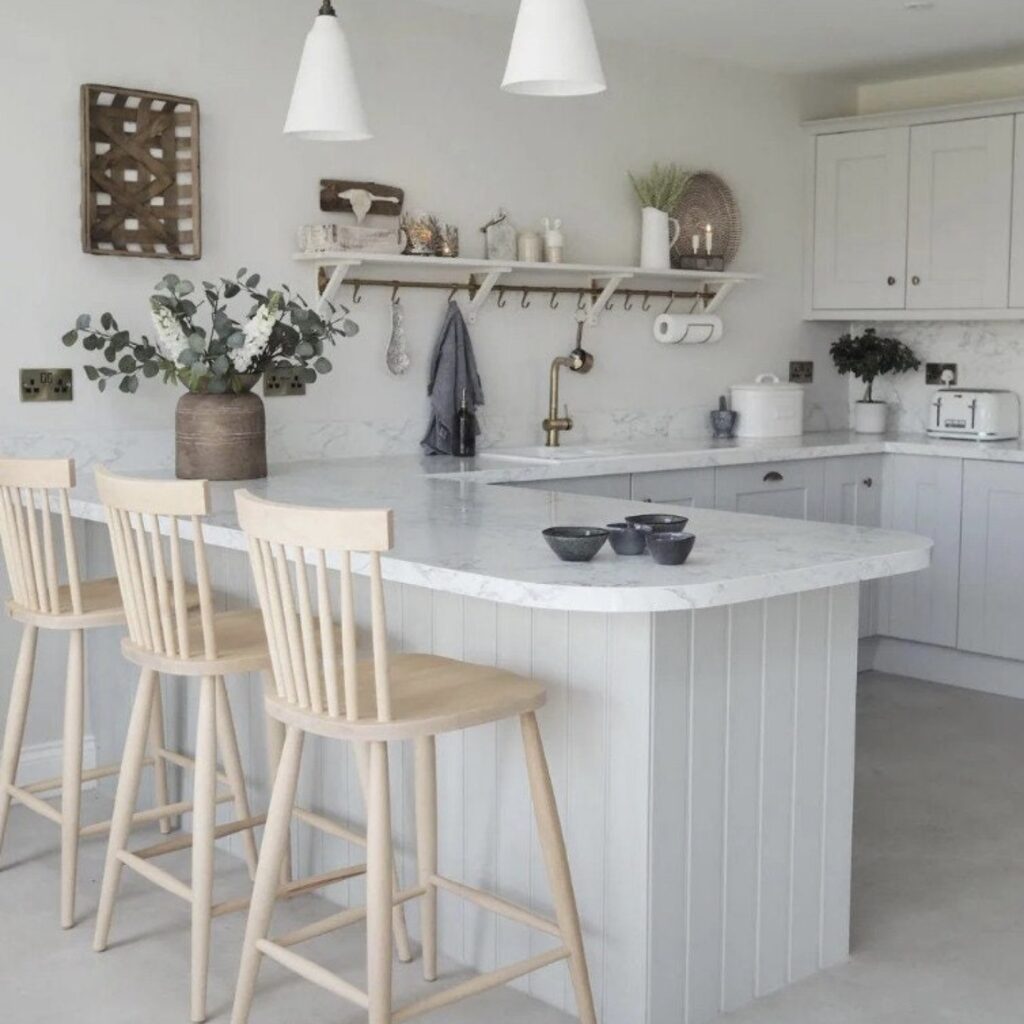 Nordic wood bar stools at white marble kitchen island Scandinavian style