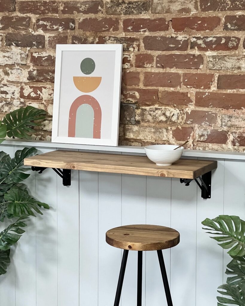 Small wall-mounted folding breakfast bar table with wooden stool in narrow kitchen space