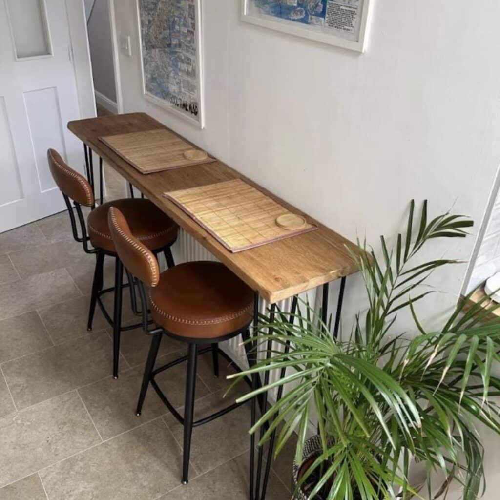 Reclaimed wood breakfast bar table with hairpin legs and leather bar stools