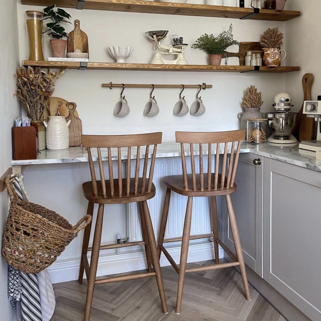 Small kitchen coffee corner with narrow breakfast bar and wood stools