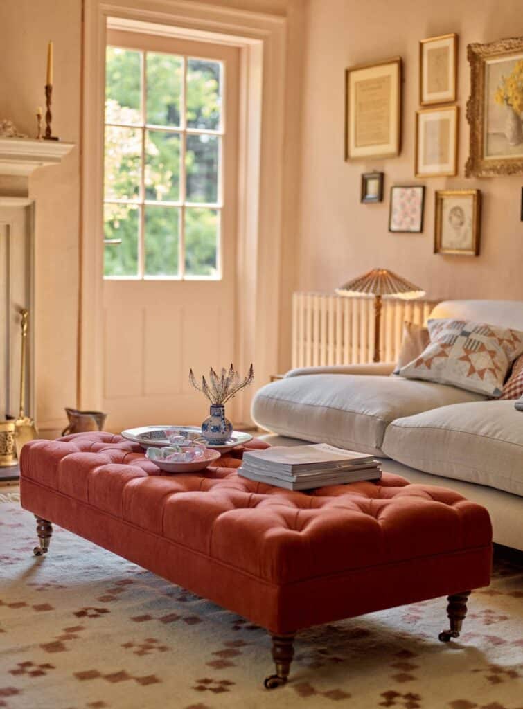 Rust linen tufted ottoman coffee table with turned oak legs in a living room