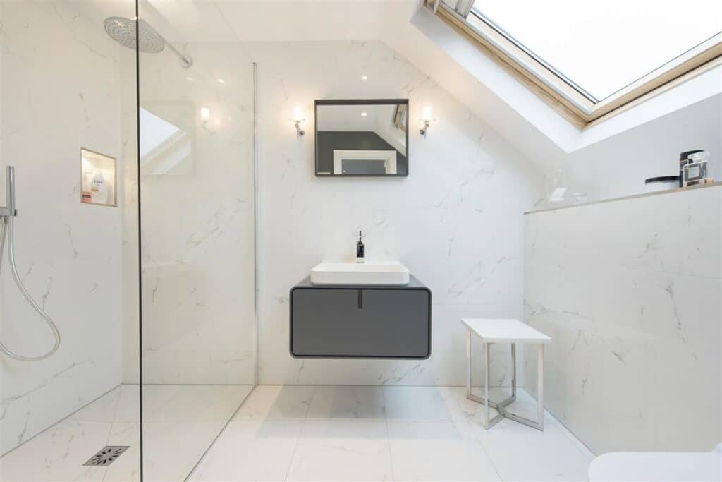 White marble bathroom with skylight, dark floating vanity, glass shower screen and Wevet by Farrow & Ball on the walls