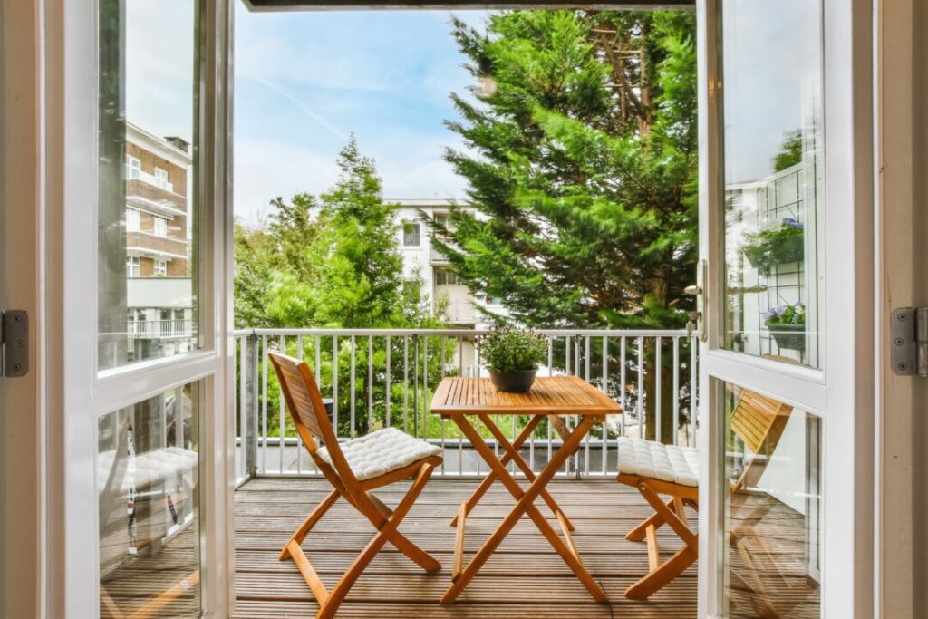 Small balcony with vertical planting and a folding wooden bistro set – a stylish and functional small balcony idea.