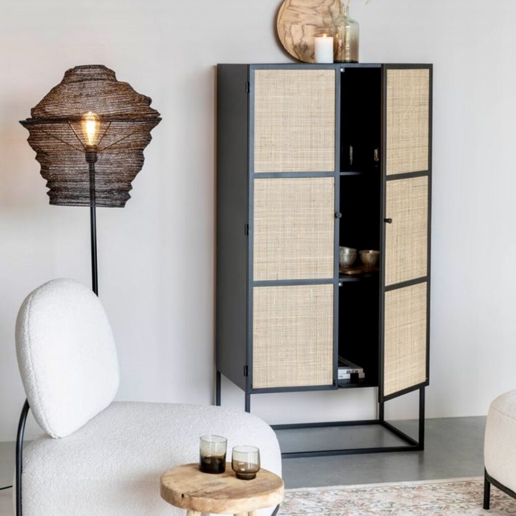 Kiku tall cabinet in Japandi style with black metal frame and natural rattan doors, styled in a minimalist room with soft lighting and textured furniture.