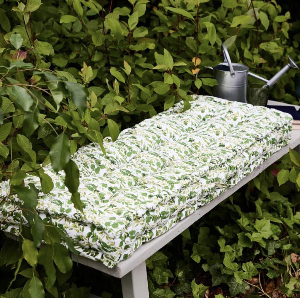 Botanical leaf print bench cushion on outdoor seating — an easy way to add comfort to a small balcony.