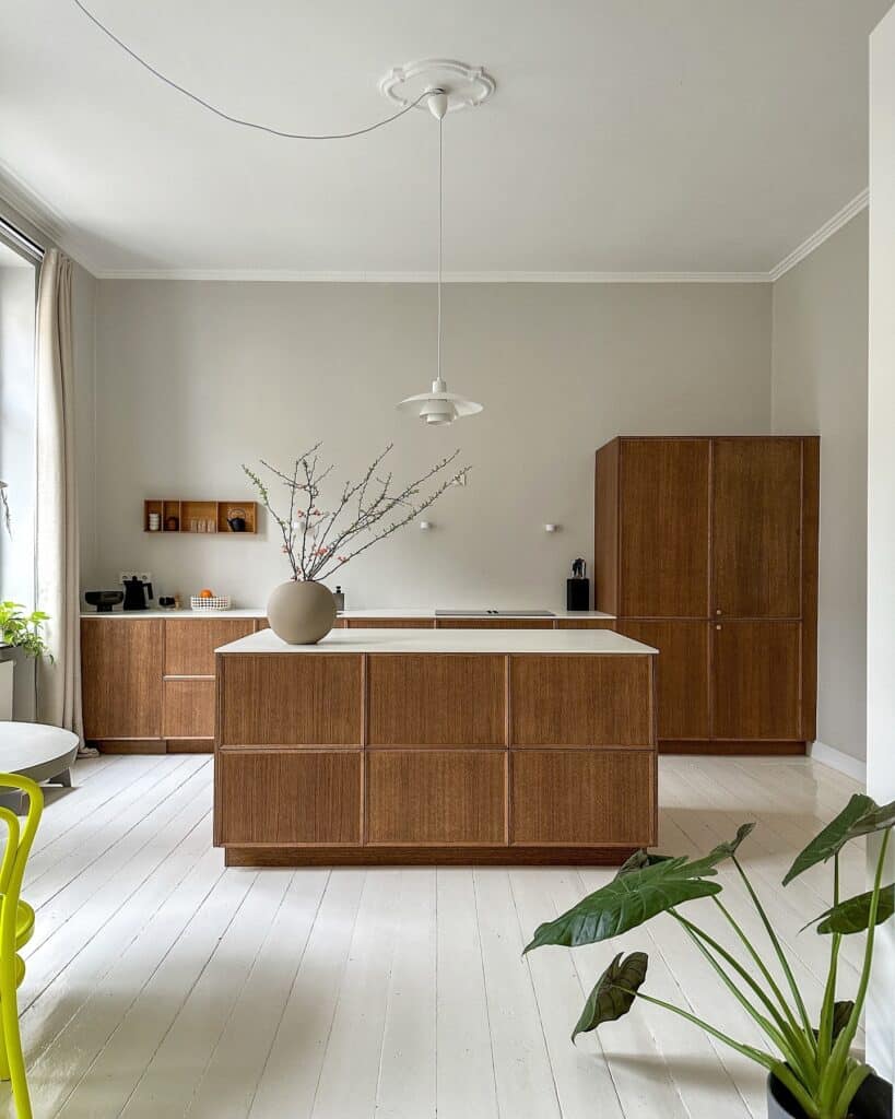 Japandi kitchen with walnut island unit, white painted floorboards and pendant light painted in Farrow and Ball Ammonite