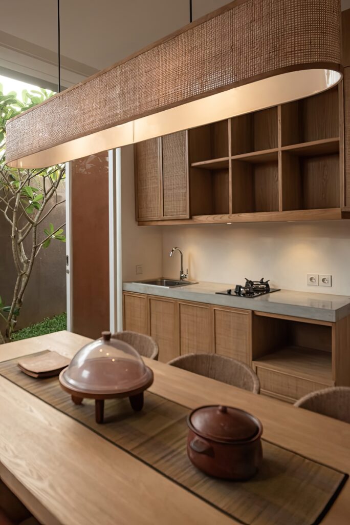 Japandi kitchen with wooden cabinetry, woven pendant lighting, and a natural dining table set
