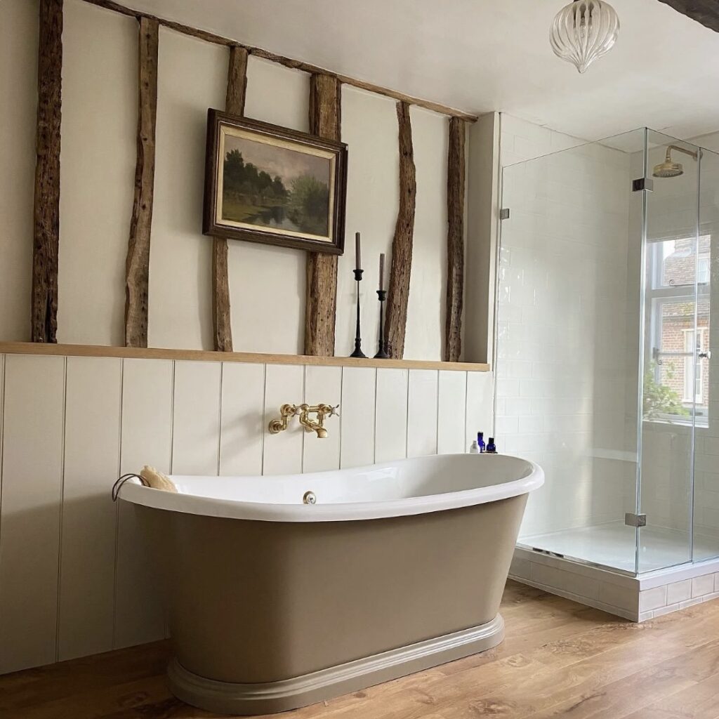 Rustic bathroom with wood panels painted in Slipper Satin and bath in Mouse’s Back by Farrow & Ball