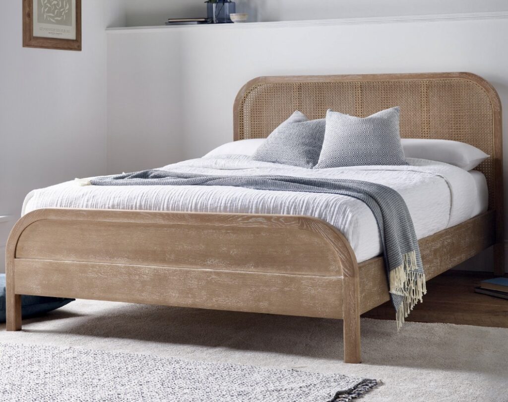 Wooden rattan bed frame in soft neutral tones — perfect for cottage bedroom ideas.
