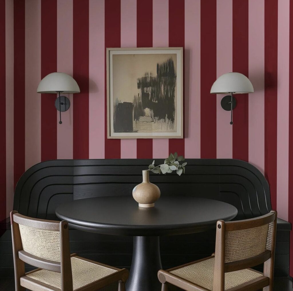 Dining area with striped burgundy wallpaper uk, curved black bench, and modern wall sconces