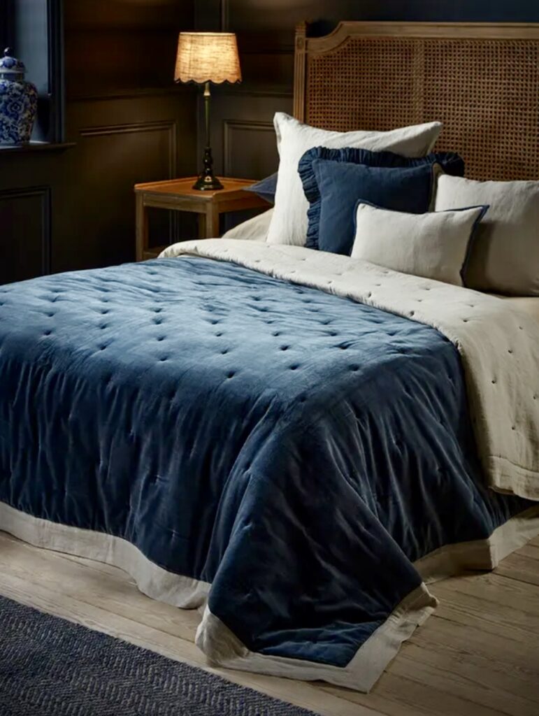 Blue velvet bedding with wicker headboard in a moody blue bedroom – blue bedroom ideas