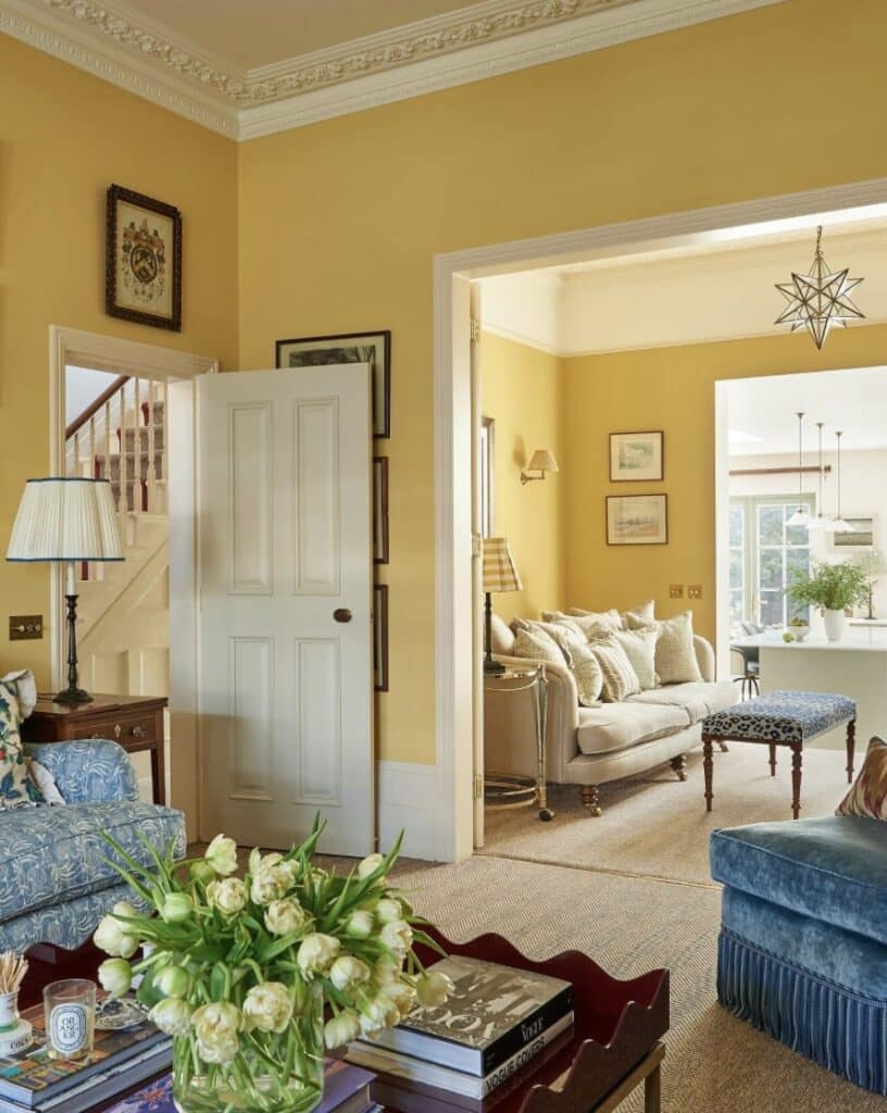 Mustard colour paint living room with warm yellow walls, creamy neutral trim and soft furnishings. Image credit: Farrow & Ball.