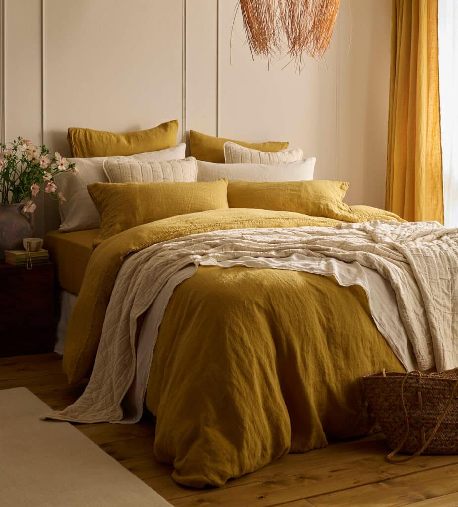 Honey mustard linen bedding in a cream panelled bedroom, mustard yellow bedroom ideas