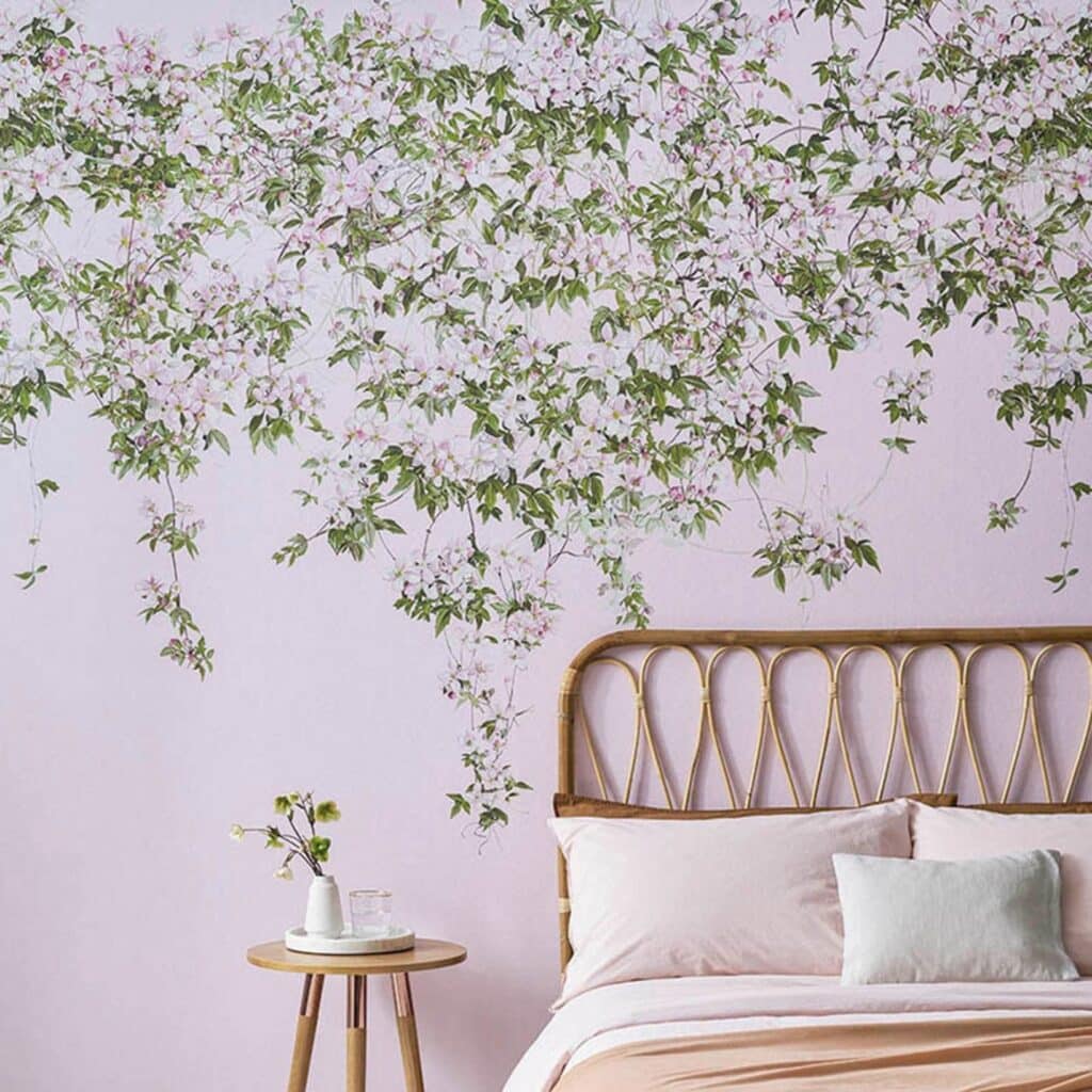 Pink clematis hanging floral wallpaper mural behind rattan bed headboard