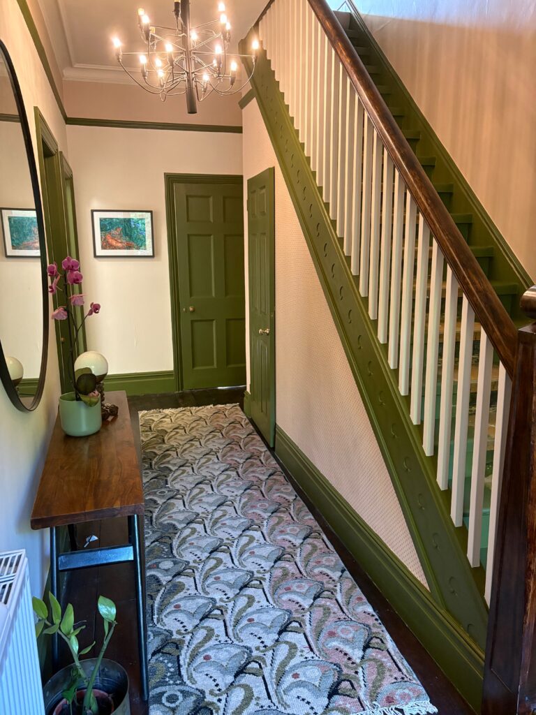 Under-stairs hallway with Polka Square dotted wallpaper and olive green panelling