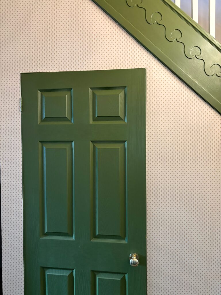 Close-up of Polka Square wallpaper dot pattern beside olive green staircase panelling