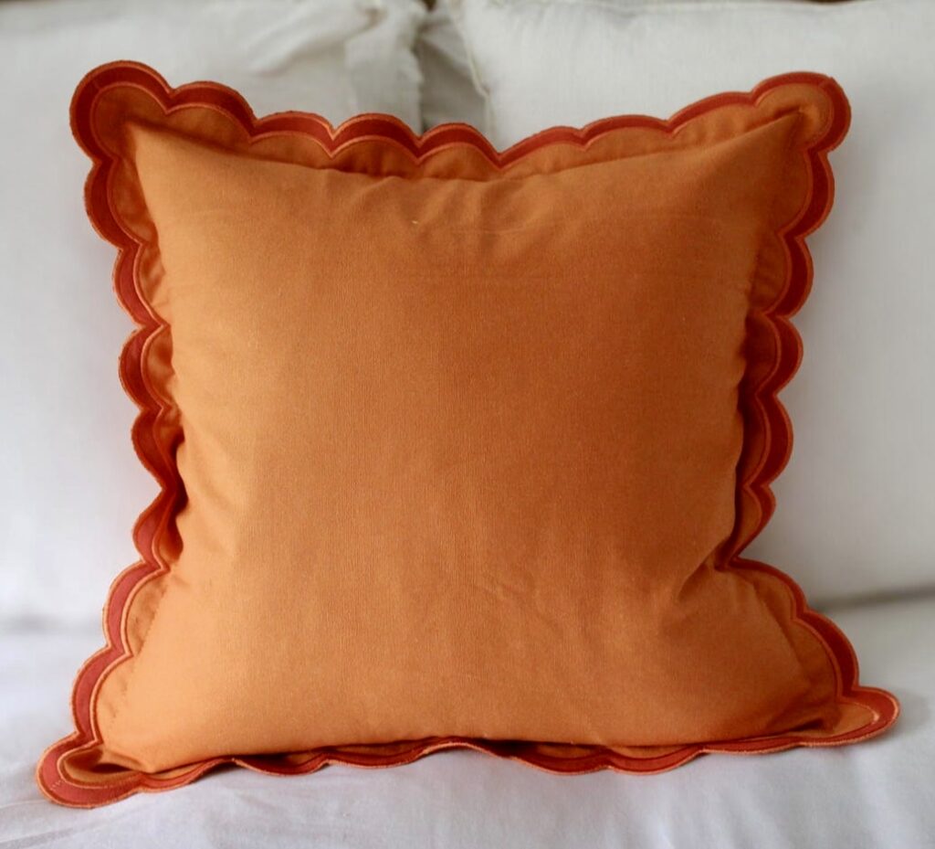 Orange scalloped edge cushion – playful orange home accessory for modern interiors