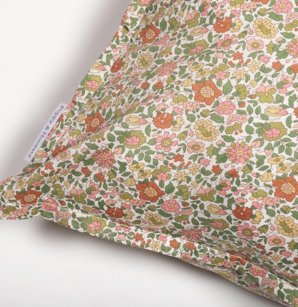 Handmade Liberty fabric pillowcase in Theresa Green – a fresh botanical pattern that complements burnt orange home accessories in a layered burnt orange bedroom scheme.