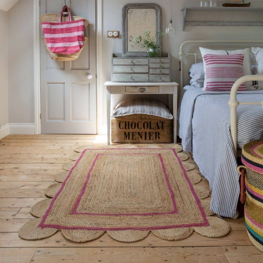 Jute scalloped edge rug with pink border styled in a relaxed bedroom