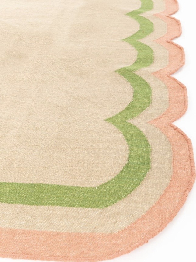 Scalloped edge rug with pink and green painted border detail