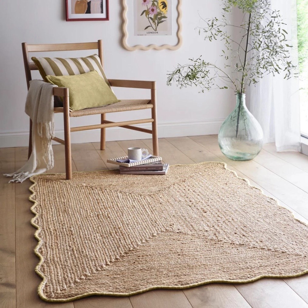 Natural woven scalloped edge rug with soft yellow trim in a bright living room