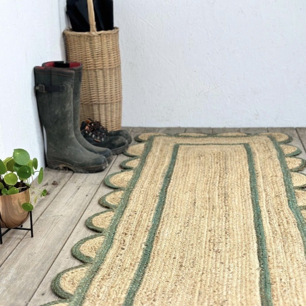 Natural jute scalloped edge runner rug with green border styled in a hallway