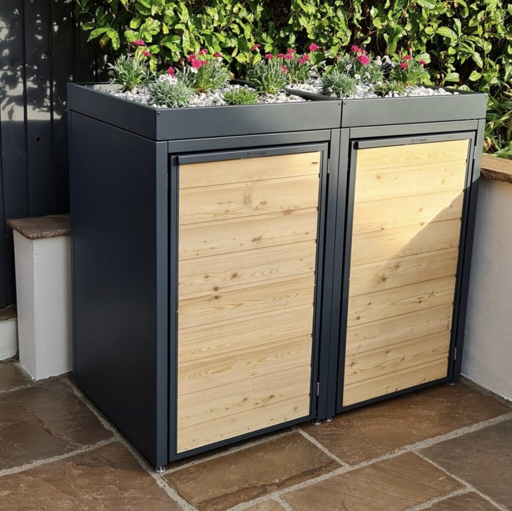 Dual wheelie bin storage unit in wood and metal with a green roof planter – stylish and secure bin storage idea