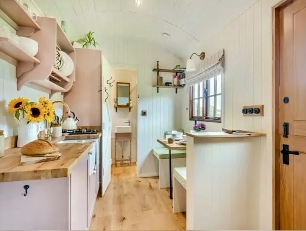 Small kitchen ideas on a budget with Sulking Room Pink and School House White cabinetry in a narrow space