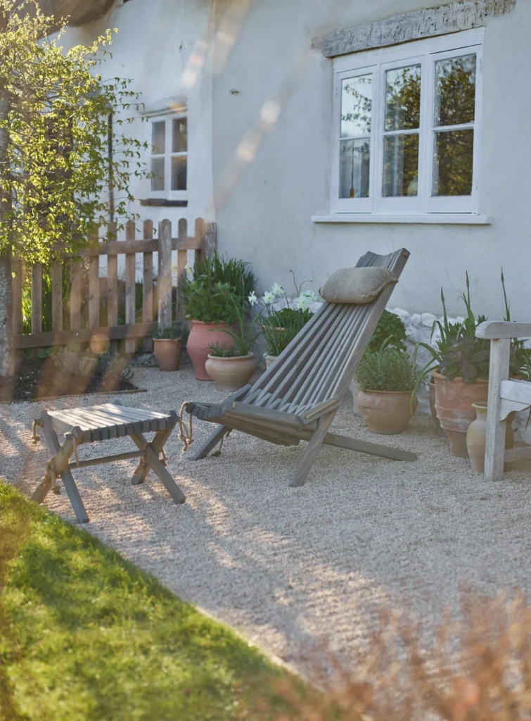 gravel garden ideas with pots Scandinavian wooden garden chair terracotta pots and rustic picket fence