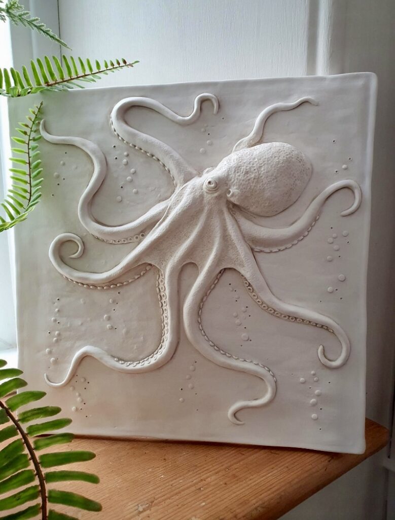 Handcrafted octopus wall plaque with fern detail in a natural seaside home interior