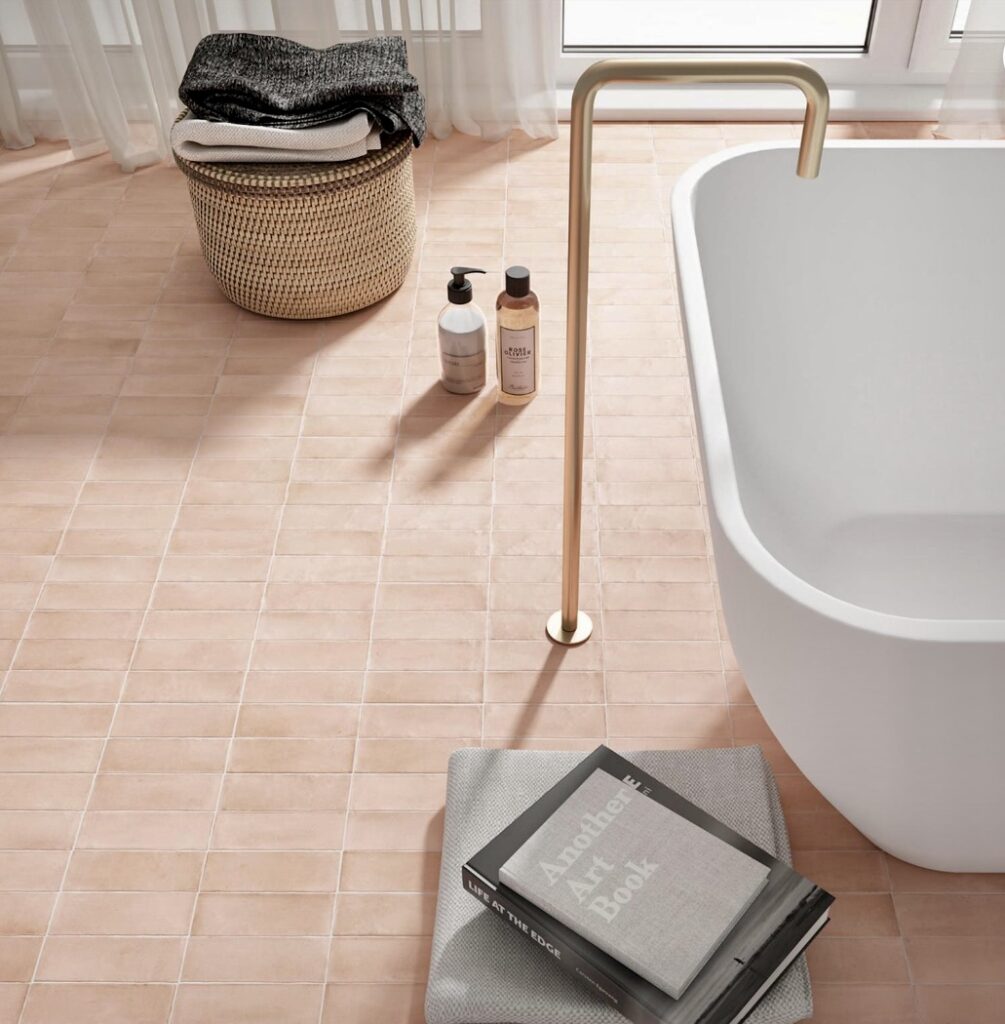 Modern pink bathroom with soft pink bathroom floor tiles and freestanding bath