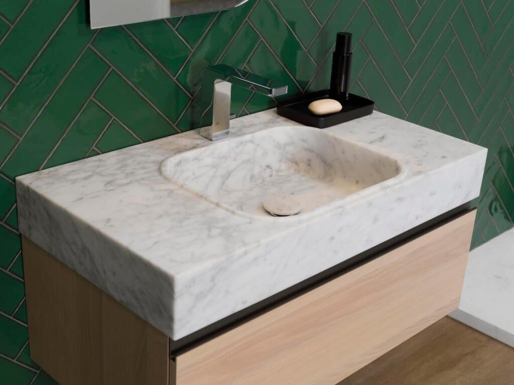 Porcelanosa Touch Bottle green herringbone tile behind a marble bathroom vanity