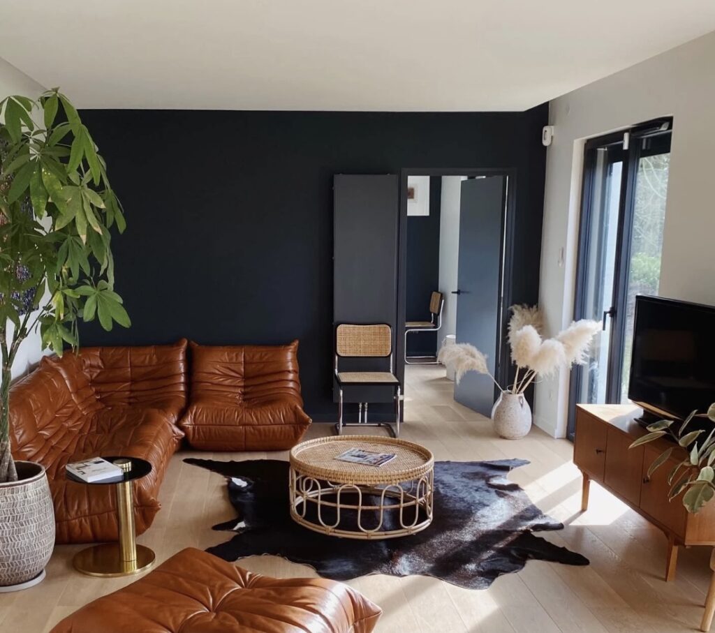 Small living room ideas with leather sofa and Hague Blue walls, featuring cosy small living room décor and a round rattan coffee table.