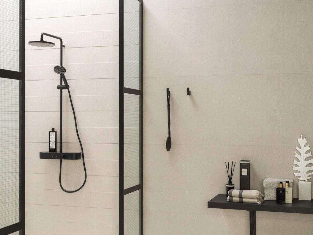Neutral bathroom ideas with Porcelanosa Line Terra Bone 59.6×150 neutral bathroom tiles, matte black shower fittings and a black-framed shower screen for a modern warm white look.