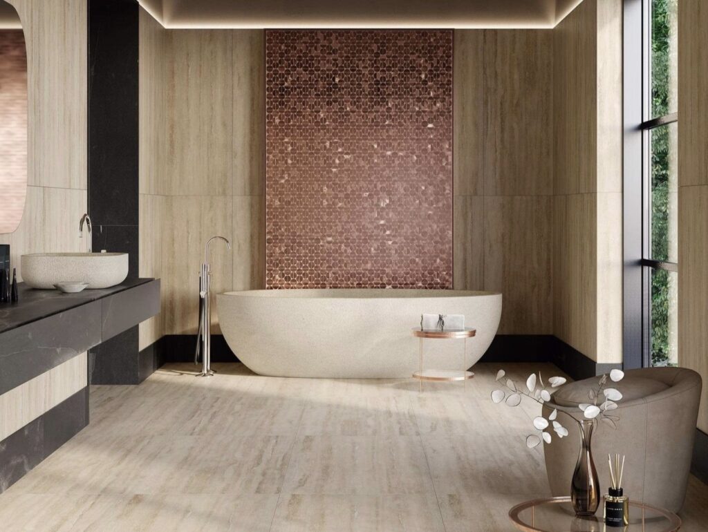 Neutral bathroom ideas with Porcelanosa Sphere Copper tile feature wall behind a freestanding bath, paired with warm wood and pale stone neutral bathroom tiles.