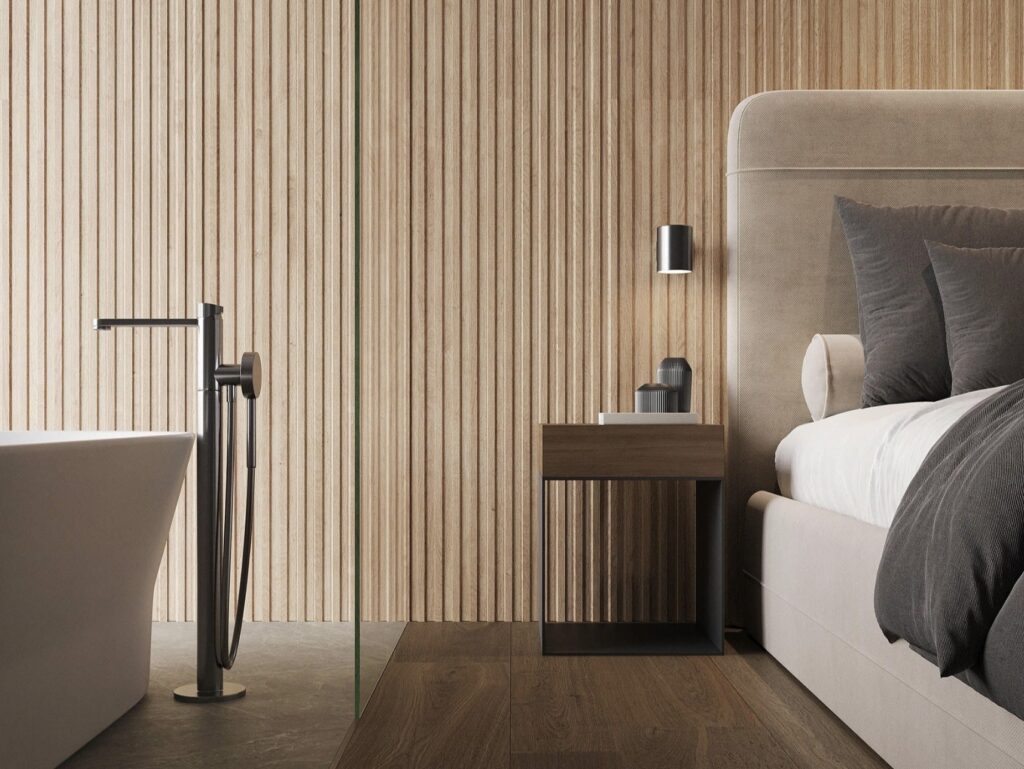 Neutral bathroom ideas showing a seamless bedroom-to-en-suite flow with Porcelanosa Line 3D Arce 59.6×150 slatted-effect tiles, warm wood tones and a freestanding bath.