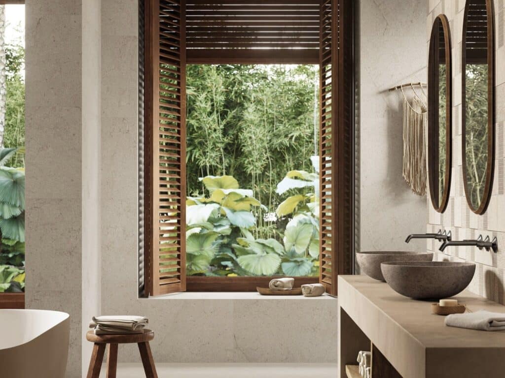 Neutral bathroom ideas with Porcelanosa Dorcia Bone 59.6×150 neutral bathroom tiles, warm wood shutters, a stone basin and a beige and oat colour palette.