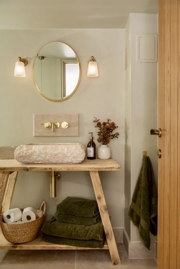 Neutral bathroom ideas with a rustic reclaimed wood vanity, stone vessel basin, brass fittings and round mirror in a cosy neutral bathroom (Image: TheDancingWoodman via Etsy).
